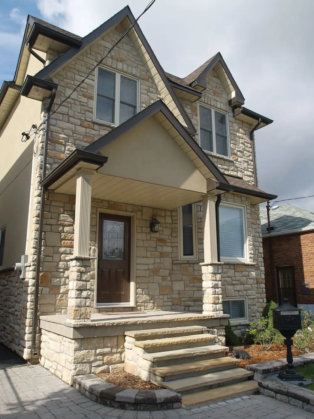 Two-storey home fully clad in Classic Cut stone veneer, with stone columns and steps