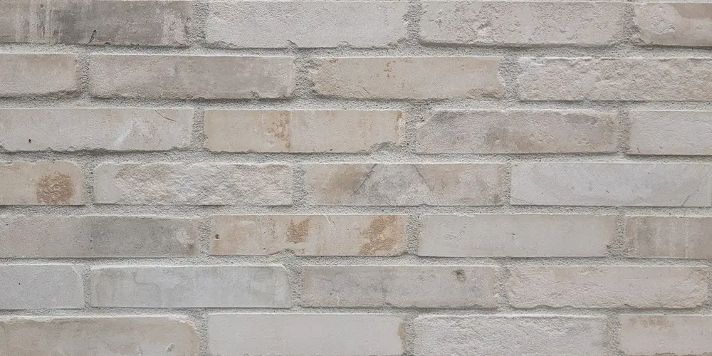 Close detail of thin brick veneer in a white-grey blend