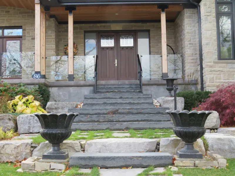 Front entrance with stone steps, columns and landscaping