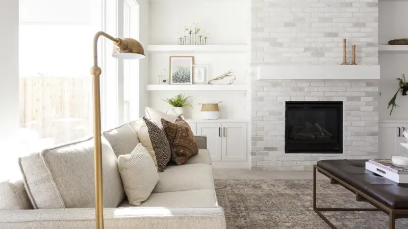 Living room with a white brick fireplace and built-in shelving
